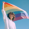 Imagem gerada por Inteligência Artificial de jovem segurando a bandeira do arco-íris (crédito: freepik)